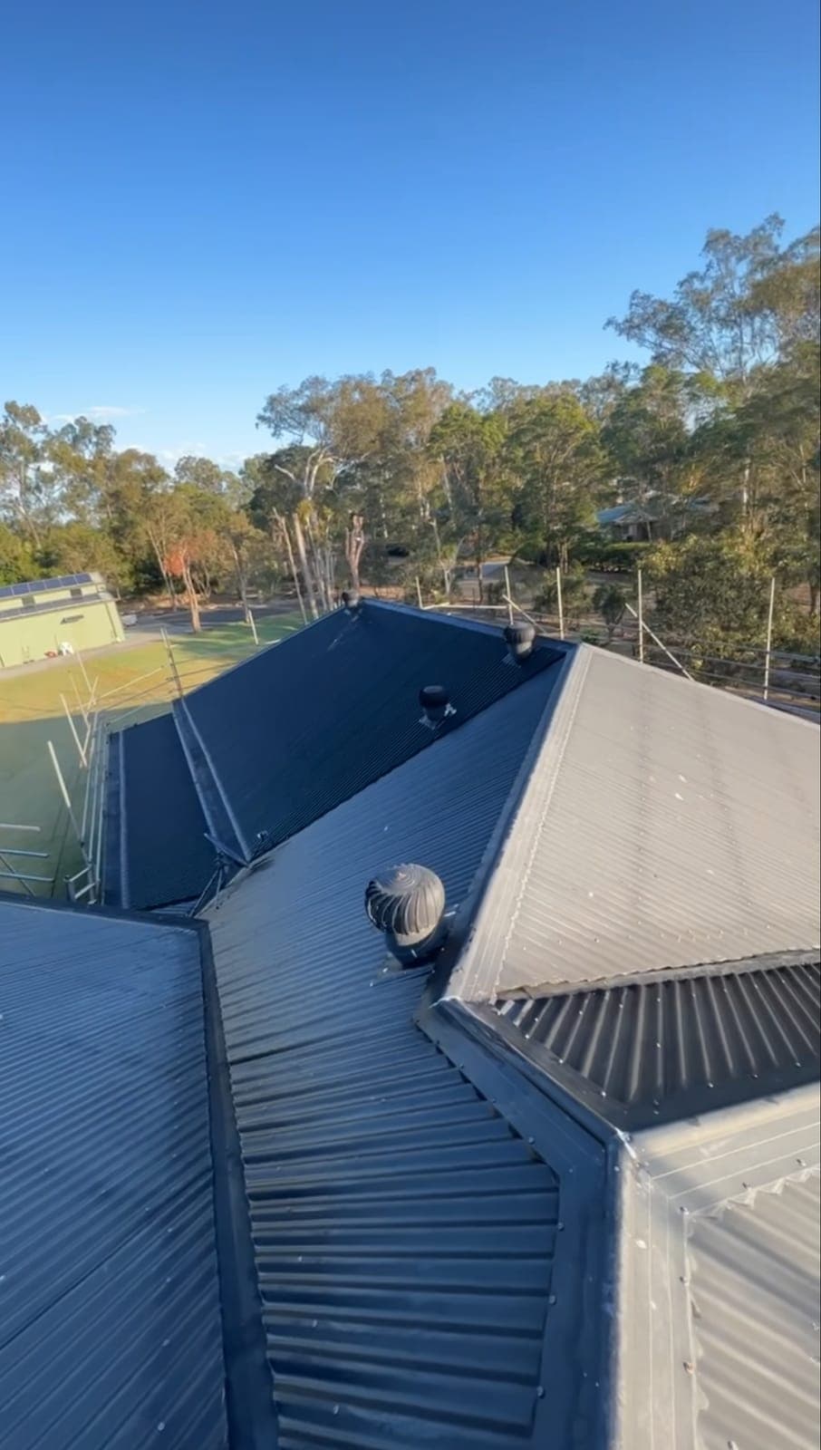 Dark grey Colorbond roof with a new whirlybird vent at sunset